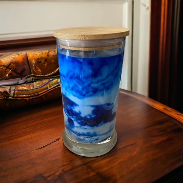 "Playing in the Rain" scented marbled candle by Owl Creek Candles. A unique, hand-poured soy wax candle with a beautiful marbled design. The candle features refreshing notes of rainwater, dewy greens, and hints of floral sweetness. Perfect for adding a touch of elegance and tranquility to any space.