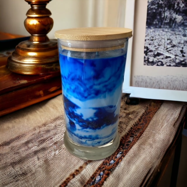 "Playing in the Rain" scented marbled candle by Owl Creek Candles. A unique, hand-poured soy wax candle with a beautiful marbled design. The candle features refreshing notes of rainwater, dewy greens, and hints of floral sweetness. Perfect for adding a touch of elegance and tranquility to any space.